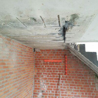 Beeld 2. Plafond van balkon. beschadigd beton. Verroeste bewapening. Bros beton. Bewapening vrijgemaakt van roest en beschermd tegen roest.